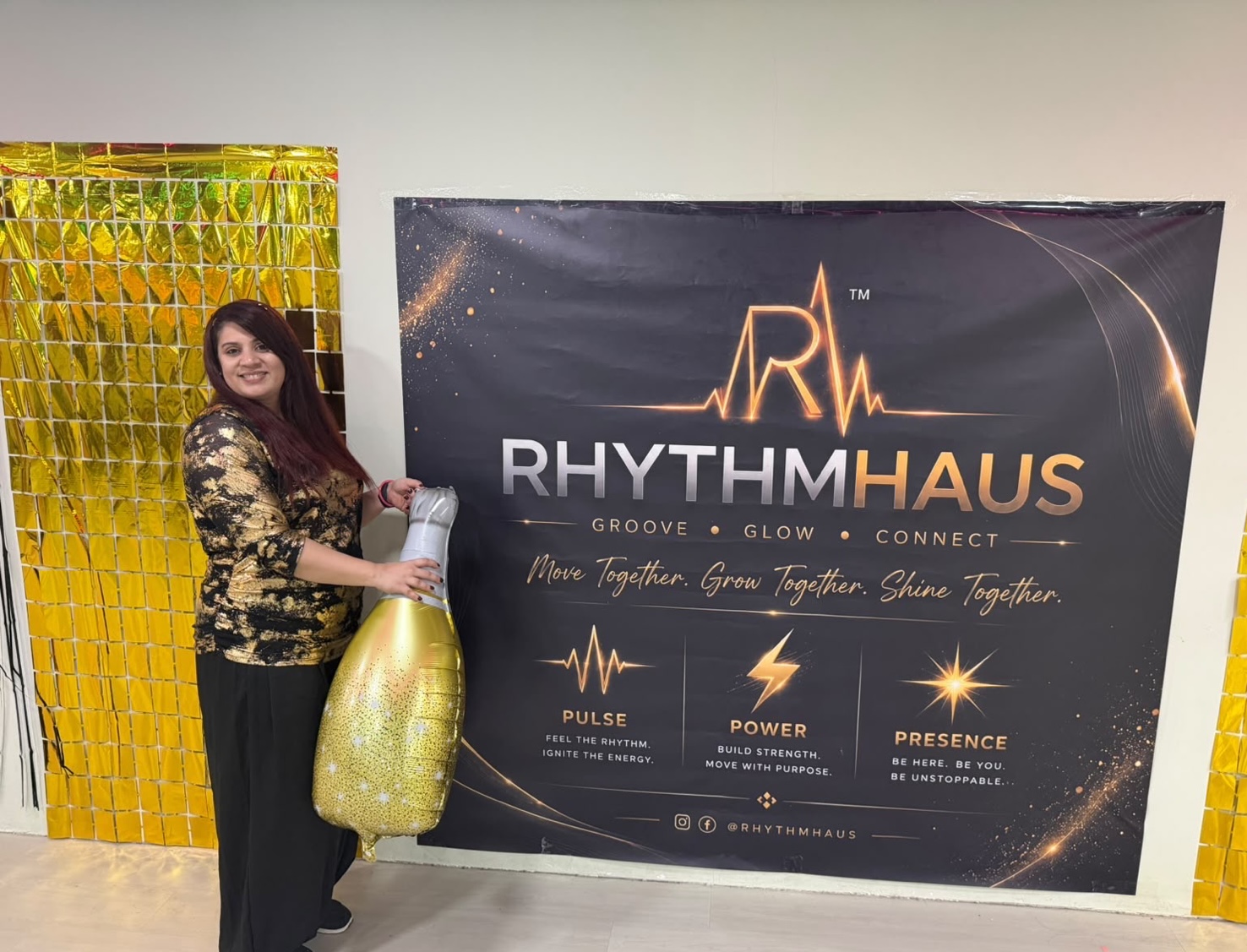 Swati Makwana smiling beside the RhythmHaus™ banner at a studio gathering
