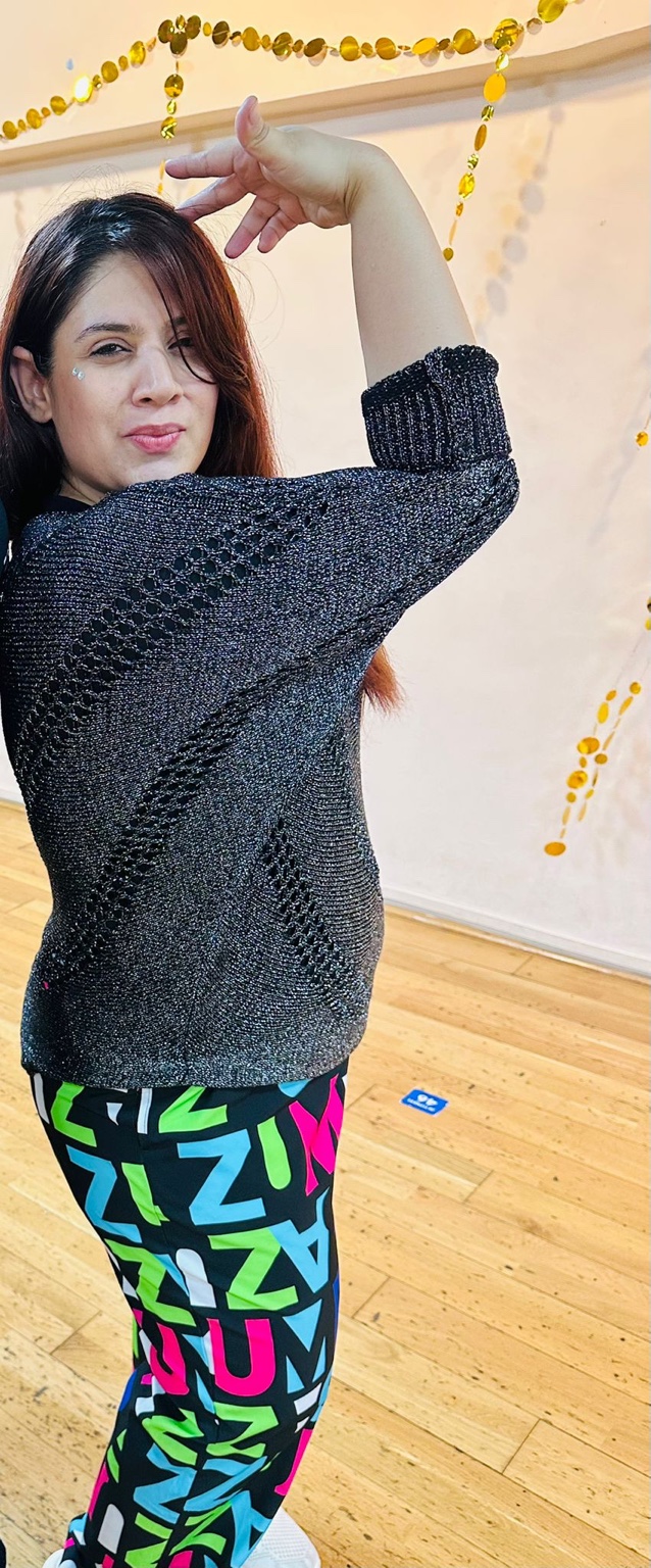 Swati in the dance studio wearing a black top and colourful trousers
